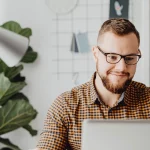 Hombre contento delante del ordenador en su blog sobre ventas en internet