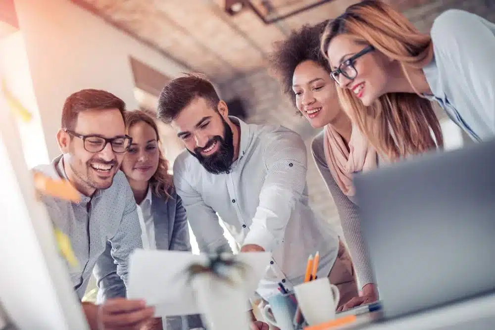 auditoria de ventas equipo sonriendo con gráficos de empresa